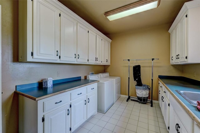 laundry room with cabinets, light tile patterned floors, and washing machine and clothes dryer