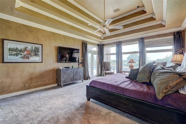 carpeted bedroom featuring ceiling fan, ornamental molding, a tray ceiling, and multiple windows