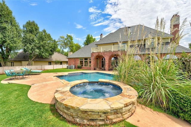 view of swimming pool featuring an in ground hot tub, a yard, and a patio