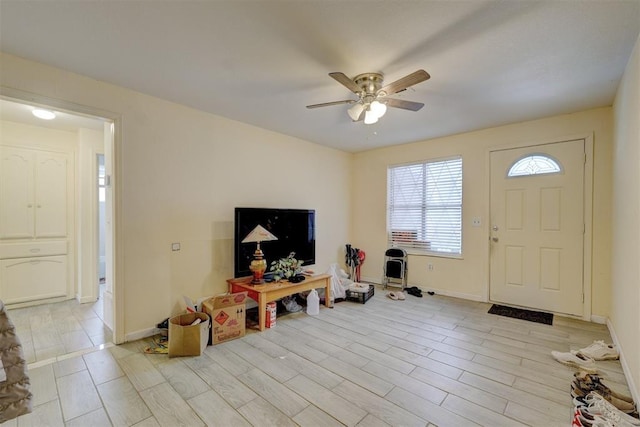 foyer featuring ceiling fan, light wood-style flooring, and baseboards