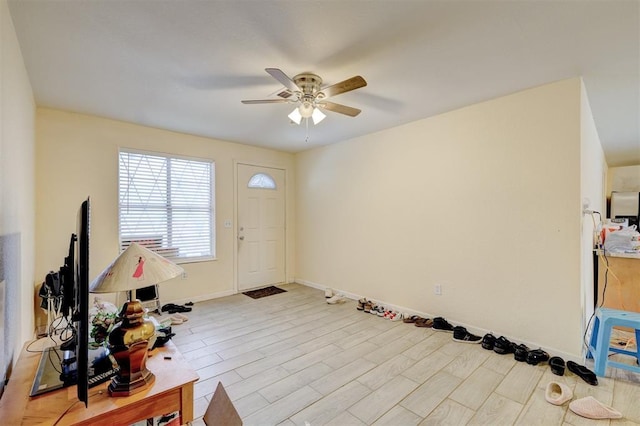 entrance foyer with light wood-type flooring, baseboards, and a ceiling fan