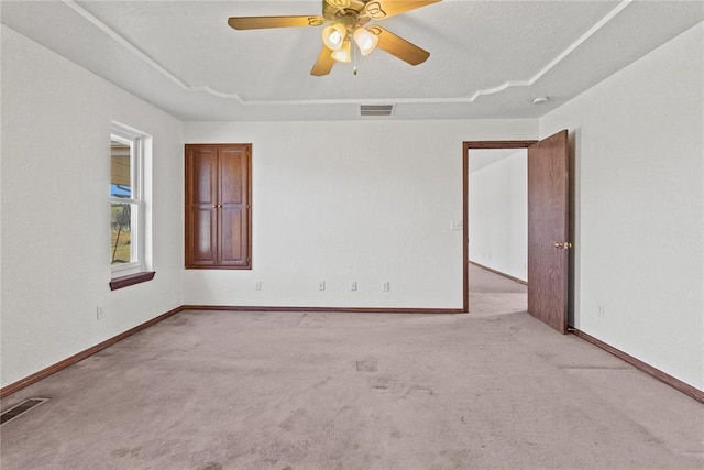 unfurnished room with ceiling fan and light carpet