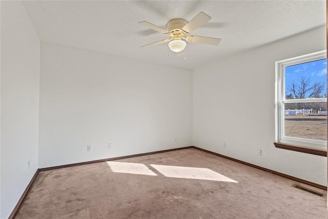 carpeted spare room featuring ceiling fan and a textured ceiling