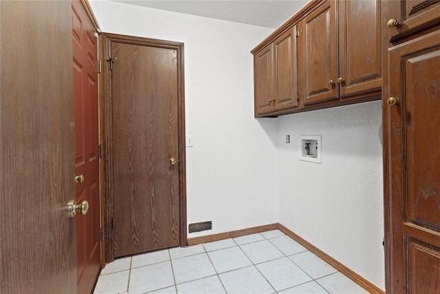 clothes washing area featuring cabinets, washer hookup, and light tile patterned floors