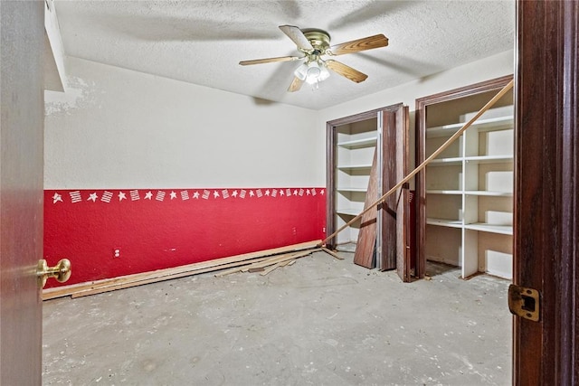 interior space featuring ceiling fan, concrete flooring, and a textured ceiling