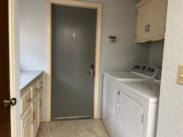 laundry area featuring marble finish floor, independent washer and dryer, and cabinet space