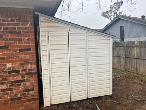 view of shed featuring fence