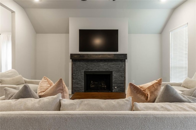 living room featuring lofted ceiling and a fireplace