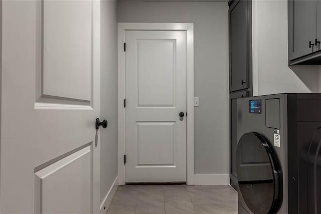 laundry room featuring washer / clothes dryer, cabinets, and light tile patterned flooring