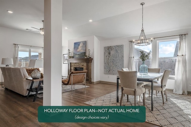 dining space with hardwood / wood-style floors, a stone fireplace, plenty of natural light, and ceiling fan with notable chandelier