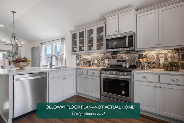 kitchen featuring lofted ceiling, sink, white cabinetry, stainless steel appliances, and decorative backsplash