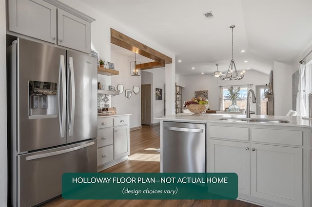 kitchen featuring dark wood-type flooring, sink, decorative light fixtures, vaulted ceiling, and appliances with stainless steel finishes