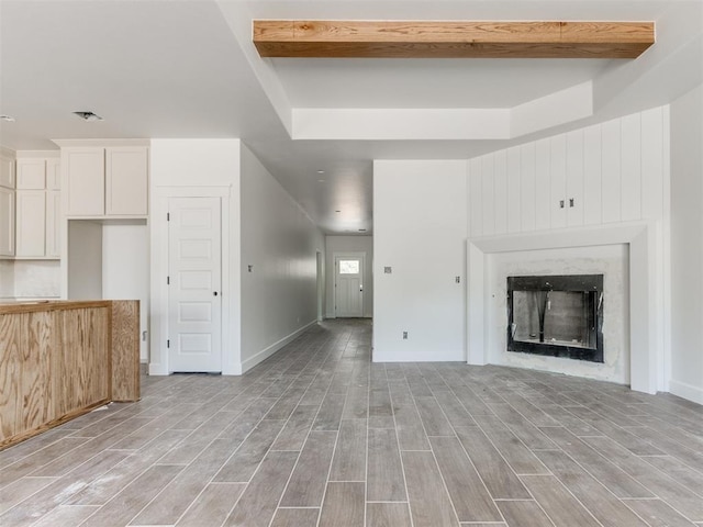 101 W 3rd St, Arcadia, OK 73007 - unfurnished living room featuring beam ceiling, light wood-style floors, and a fireplace