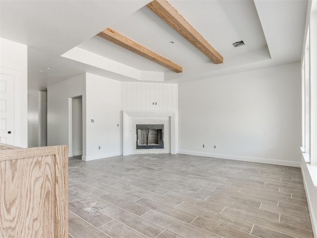 101 W 3rd St, Arcadia, OK 73007 - unfurnished living room featuring visible vents, baseboards, light wood-type flooring, a fireplace, and beam ceiling