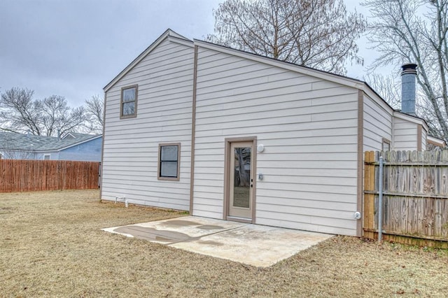 back of house featuring a lawn and a patio area