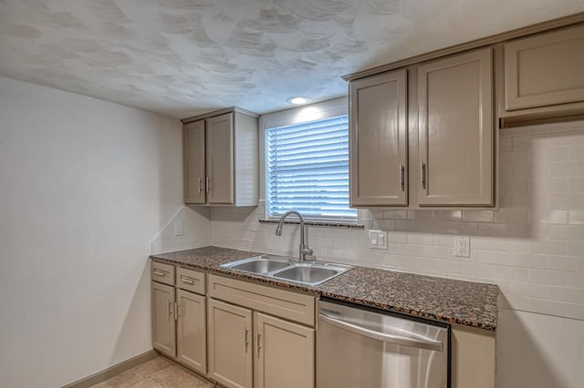 kitchen featuring sink, light tile patterned floors, backsplash, stainless steel dishwasher, and dark stone counters