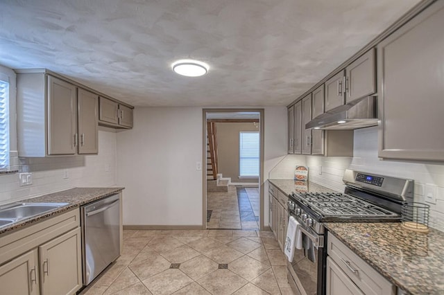 kitchen with tasteful backsplash, stainless steel appliances, and dark stone countertops