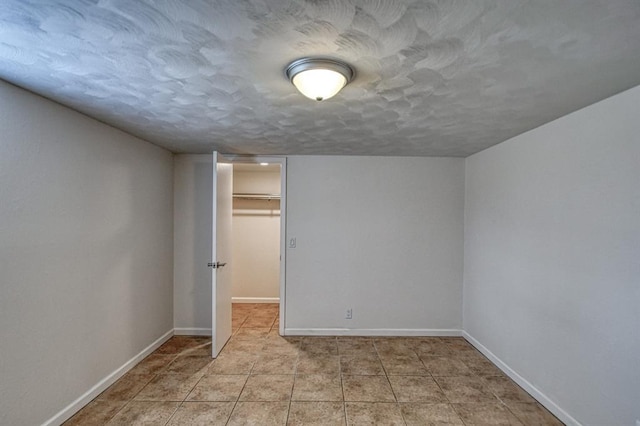 interior space featuring light tile patterned floors and a textured ceiling