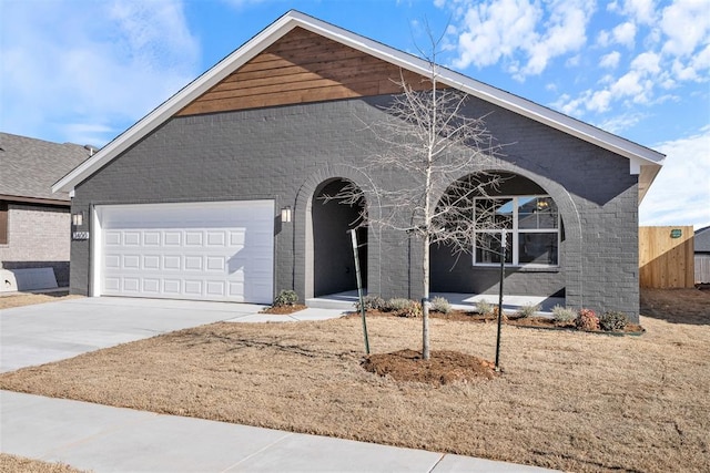 view of front of property with driveway, brick siding, and an attached garage