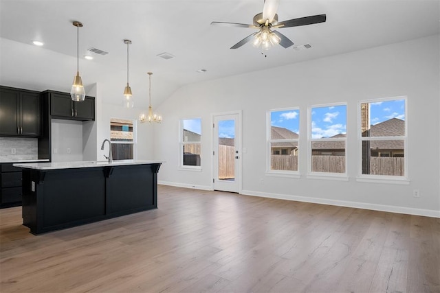 3400 Piney River Dr, Yukon, OK 73099 - kitchen with a sink, visible vents, a healthy amount of sunlight, light countertops, and dark cabinetry