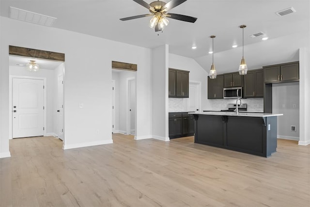 3400 Piney River Dr, Yukon, OK 73099 - kitchen featuring visible vents, a ceiling fan, light countertops, backsplash, and stainless steel microwave