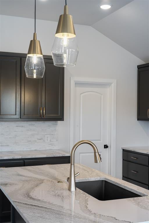 3400 Piney River Dr, Yukon, OK 73099 - kitchen featuring lofted ceiling, a sink, light stone countertops, tasteful backsplash, and decorative light fixtures