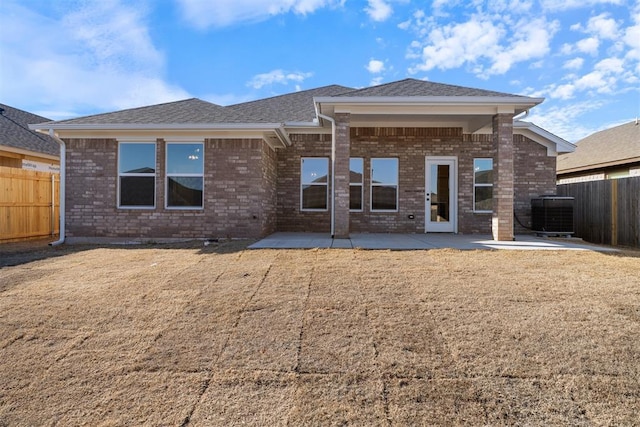 3400 Piney River Dr, Yukon, OK 73099 - back of property with brick siding, a fenced backyard, central AC, and a patio