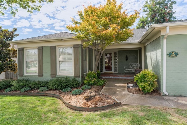 doorway to property featuring a lawn