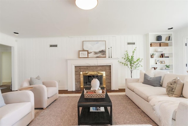 living room featuring built in shelves and hardwood / wood-style floors