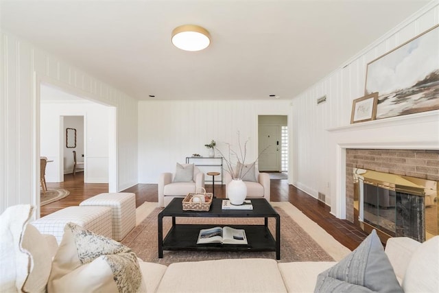 living room with a fireplace and dark wood-type flooring