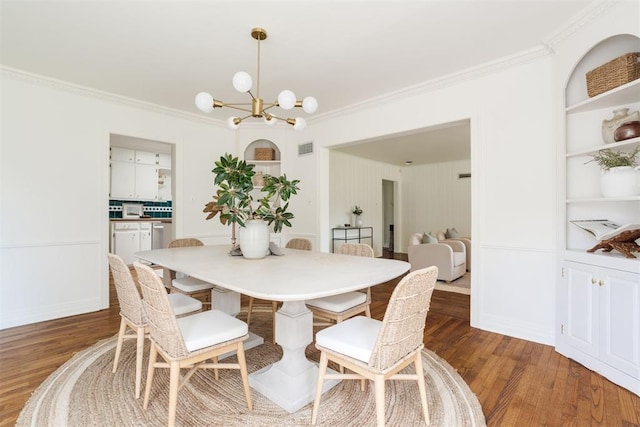 dining room featuring dark hardwood / wood-style flooring, ornamental molding, and a chandelier