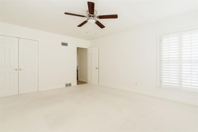 unfurnished bedroom with light colored carpet, ceiling fan, and a closet