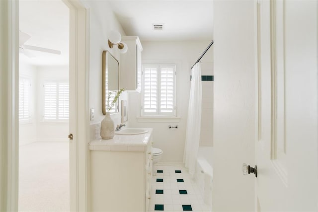 full bathroom with shower / bathtub combination with curtain, vanity, and toilet