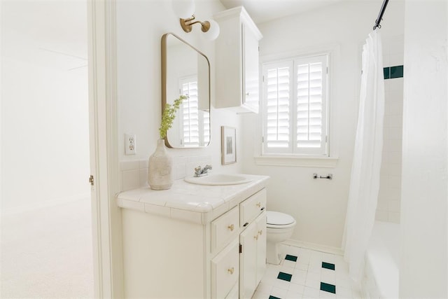 full bathroom featuring tile patterned flooring, vanity, shower / bath combo with shower curtain, and toilet