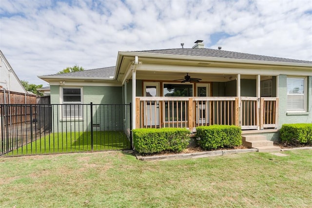 rear view of property with a yard and ceiling fan