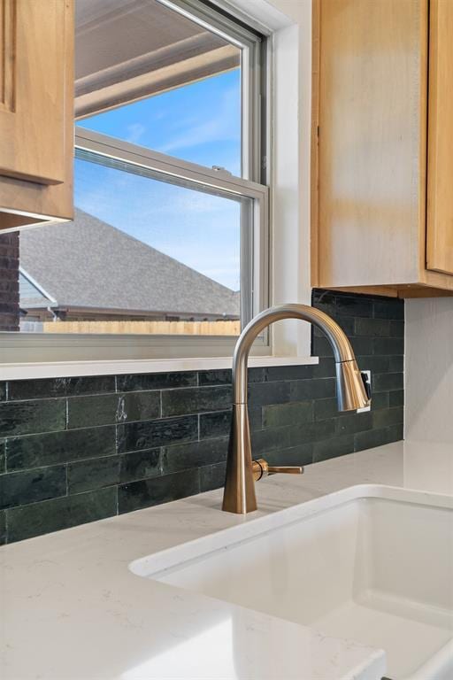 details with light countertops, backsplash, and a sink