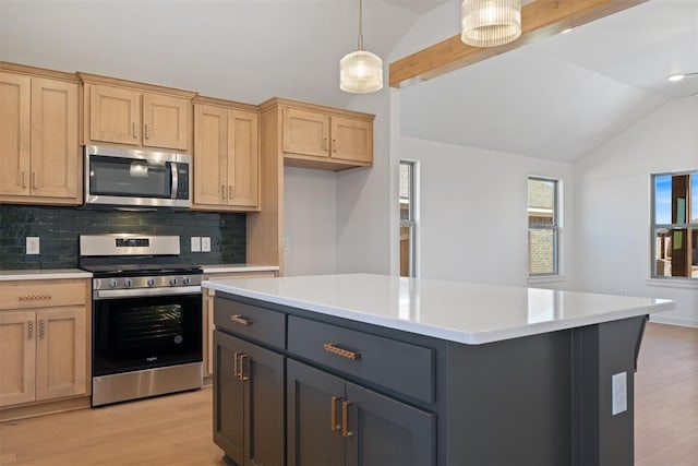 kitchen featuring vaulted ceiling, light countertops, appliances with stainless steel finishes, and light wood-style flooring