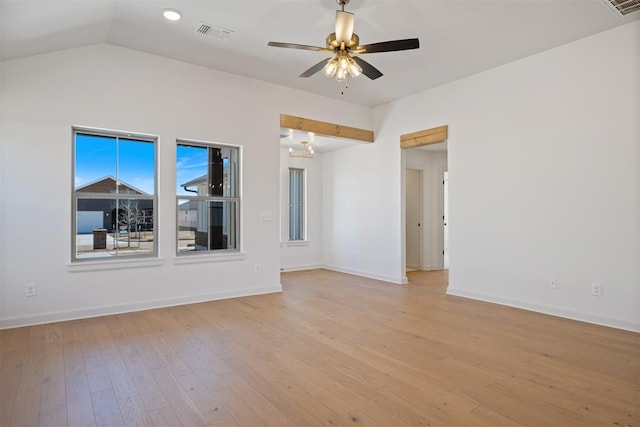 spare room with light wood-style flooring, visible vents, baseboards, vaulted ceiling, and a ceiling fan