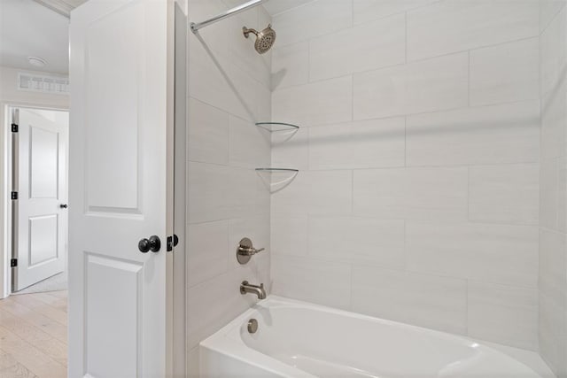 full bathroom with shower / bathing tub combination, wood finished floors, and visible vents