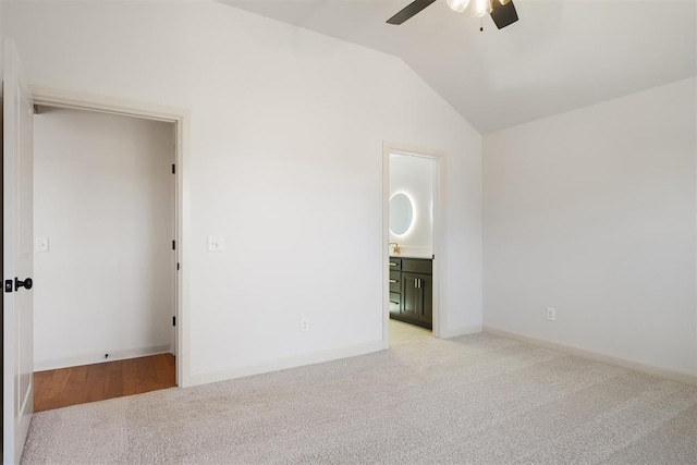 unfurnished bedroom with lofted ceiling, ceiling fan, light carpet, and ensuite bathroom