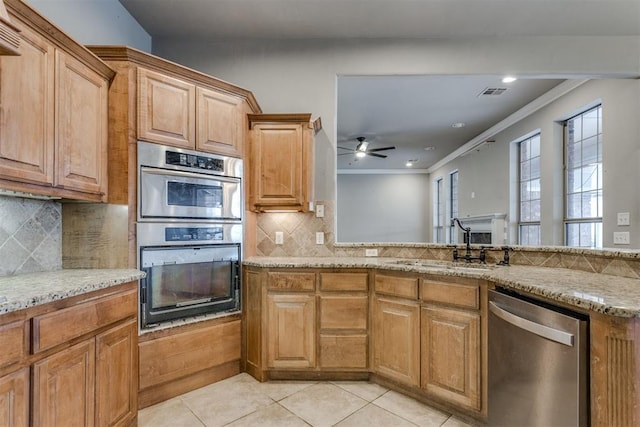 kitchen featuring sink, light tile patterned floors, light stone counters, stainless steel appliances, and crown molding