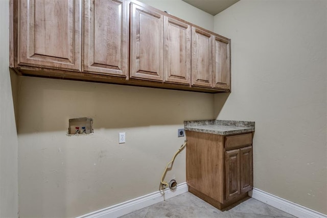 laundry room featuring cabinets, electric dryer hookup, washer hookup, and light tile patterned floors