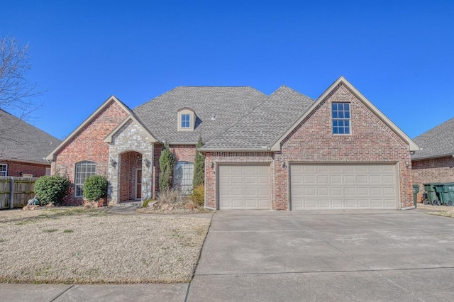 view of front of home with fence, brick siding, driveway, and a shingled roof