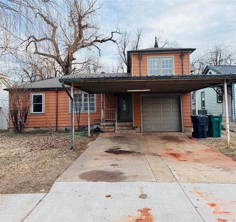 view of front of property with a garage and a carport