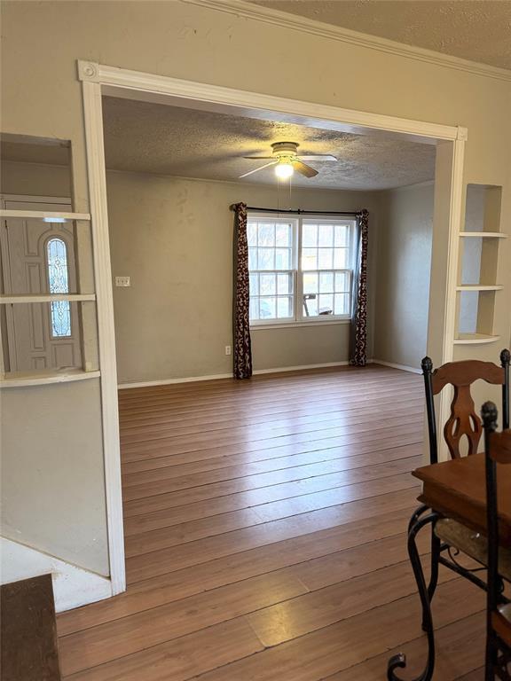 dining area with hardwood / wood-style floors, ornamental molding, a textured ceiling, and ceiling fan