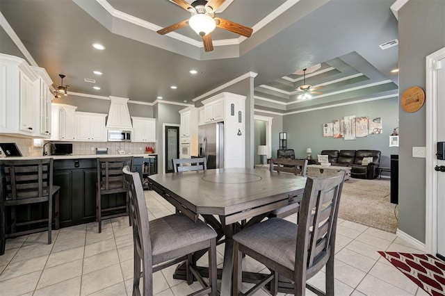 tiled dining area featuring ceiling fan, ornamental molding, a raised ceiling, and sink