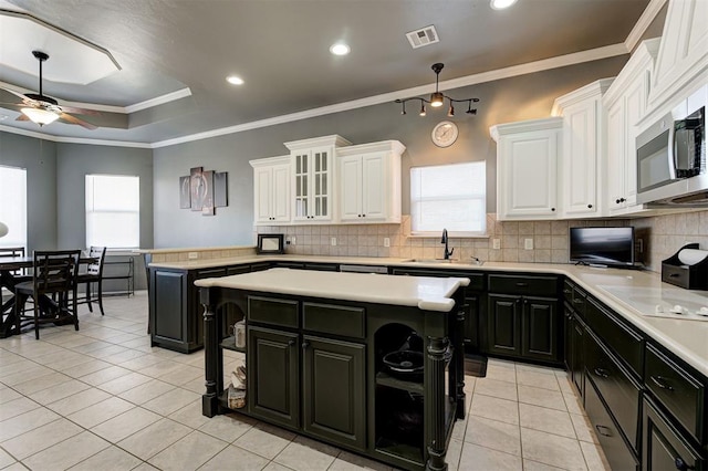 kitchen with light tile patterned floors, sink, ceiling fan, white cabinetry, and a kitchen island