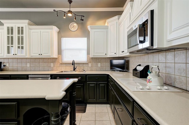 kitchen featuring decorative light fixtures, tasteful backsplash, sink, white cabinets, and crown molding