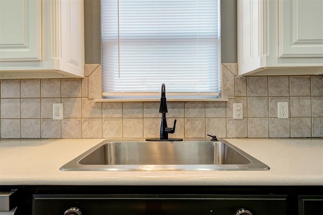 details with white cabinetry, sink, and decorative backsplash