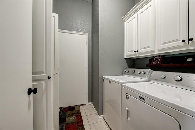 laundry room featuring cabinets, washer and dryer, and light tile patterned floors